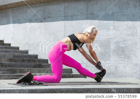 A young athletic woman working out at the city's street 55378599