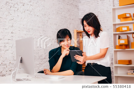Asian businesswomen using tablet in office Asian businesswomen using tablet in office 55380418