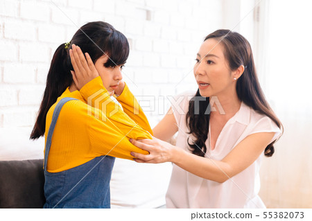Argument between annoyed Asian teenage daughter and upset middle aged mother. 55382073
