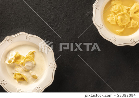 Tortellini served with broth and cream sauce, Italian food on a black background Tortellini served with broth and cream sauce, Italian food on a black background 55382094