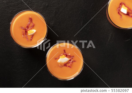 Salmorejo, Spanish cold tomato and bread soup, in glasses, shot from the top on a black background 55382097