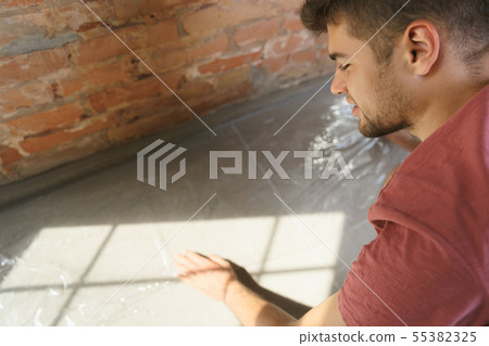 Young man doing apartment repair hisselfes Young man doing apartment repair hisselfes 55382325