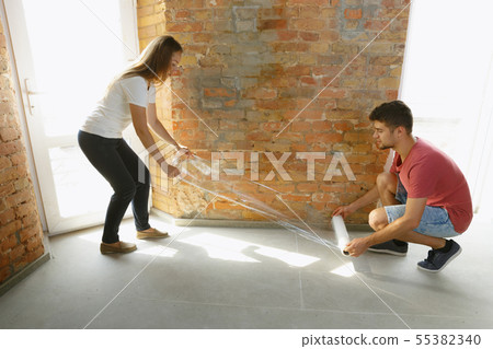 Young couple doing apartment repair together themselves Young couple doing apartment repair together themselves 55382340