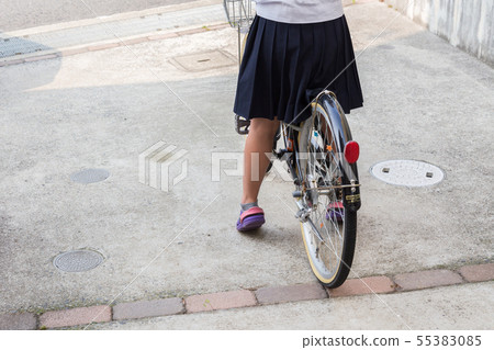 A girl riding a bicycle A girl riding a bicycle 55383085