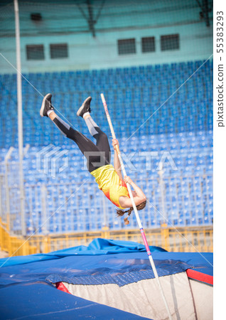 Pole vault - a female jumper falling down after the jump in the stadium Pole vault - a female jumper falling down after the jump in the stadium 55383293