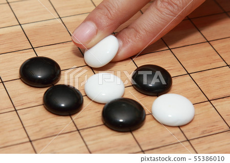 hand playing go a strategicboard  game 55386010