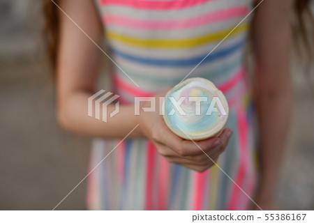 Little girl eat ice cream at an outdoor In a 55386167