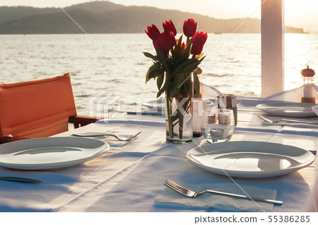 table set with flowers at beach restaurant 55386285