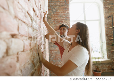 Young couple doing apartment repair together themselves Young couple doing apartment repair together themselves 55386702