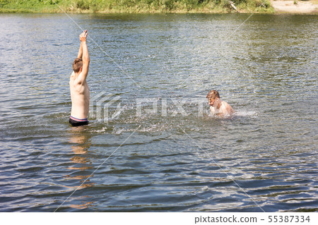 two friends are swimming in the river. two friends are swimming in the river. 55387334