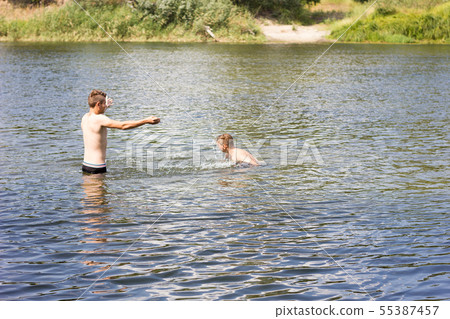 two friends are swimming in the river. two friends are swimming in the river. 55387457