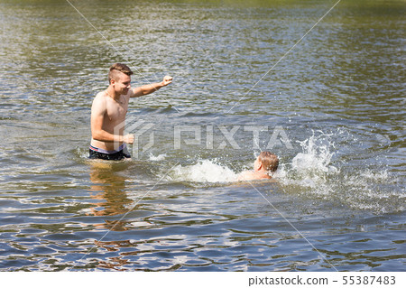 two friends are swimming in the river. two friends are swimming in the river. 55387483