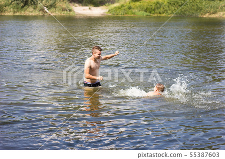 two friends are swimming in the river. two friends are swimming in the river. 55387603