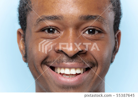 Close up portrait of young man on blue background. 55387645