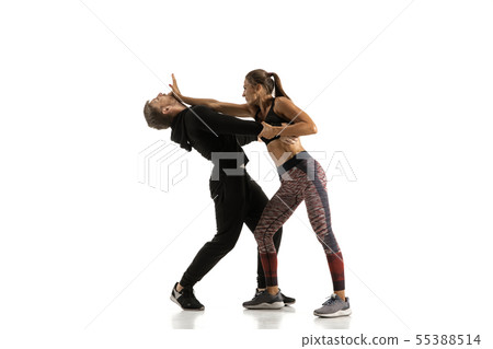 Man and woman fighting in studio, women's self-defense concept Man and woman fighting in studio, women's self-defense concept 55388514