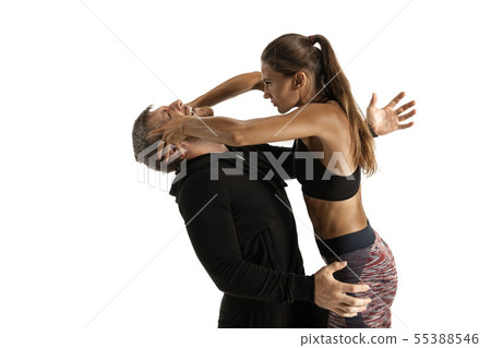 Man and woman fighting in studio, women's self-defense concept Man and woman fighting in studio, women's self-defense concept 55388546