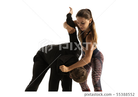 Man and woman fighting in studio, women's self-defense concept Man and woman fighting in studio, women's self-defense concept 55388552