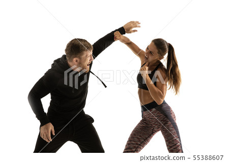 Man and woman fighting in studio, women's self-defense concept Man and woman fighting in studio, women's self-defense concept 55388607