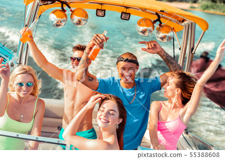 Young people drinking and dancing on the deck Young people drinking and dancing on the deck 55388608