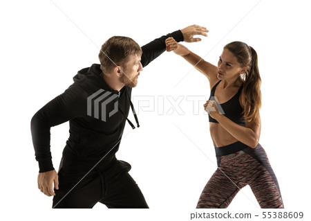 Man and woman fighting in studio, women's self-defense concept Man and woman fighting in studio, women's self-defense concept 55388609