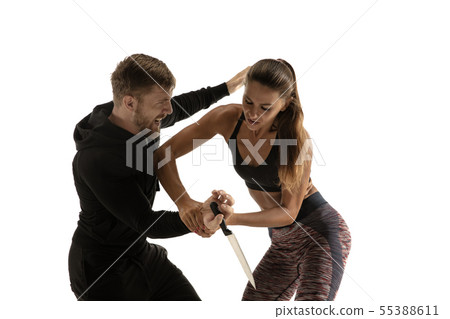 Man and woman fighting in studio, women's self-defense concept Man and woman fighting in studio, women's self-defense concept 55388611