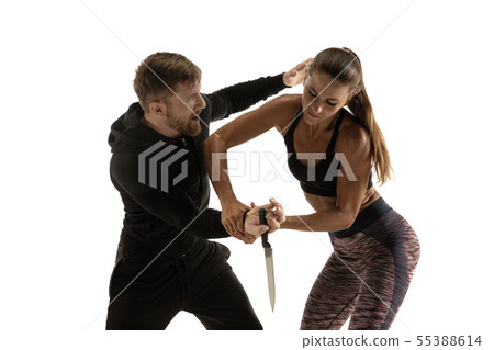 Man and woman fighting in studio, women's self-defense concept Man and woman fighting in studio, women's self-defense concept 55388614