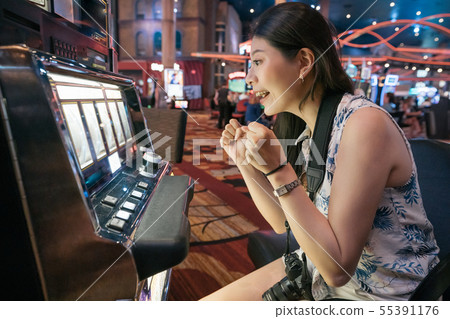 girl tourist playing slot machine in casino girl tourist playing slot machine in casino 55391176