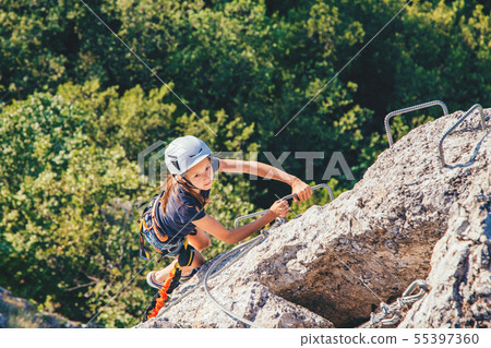 Kid girl climbing mountain.  55397360