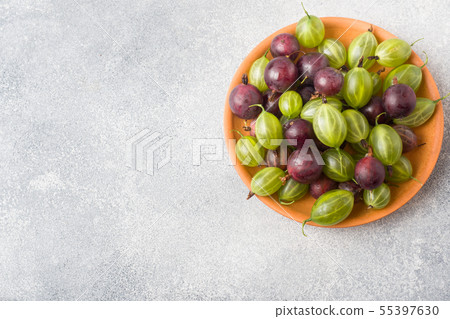 Red and green gooseberry berries in a plate 55397630