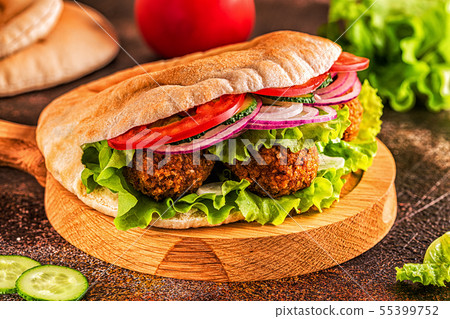 Falafel and fresh vegetables in pita bread. 55399752
