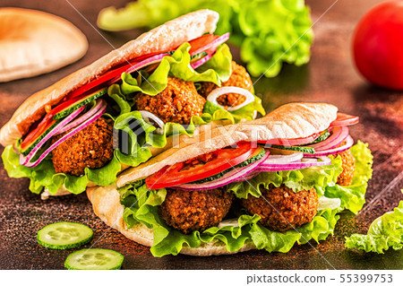 Falafel and fresh vegetables in pita bread. Falafel and fresh vegetables in pita bread. 55399753