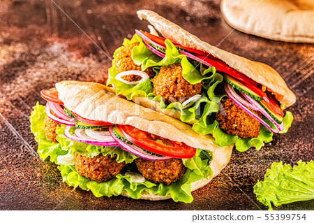 Falafel and fresh vegetables in pita bread. Falafel and fresh vegetables in pita bread. 55399754