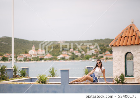 Fashion model in blue shorts and white shirt posing for photographer in beautiful inflow. Stylish 55400173