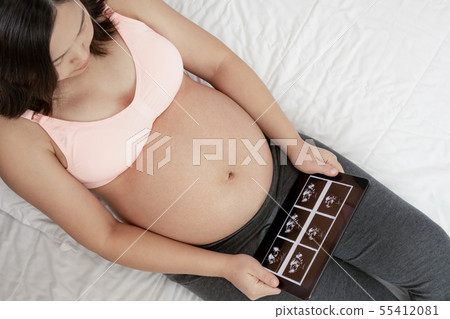 Happy pregnant woman and expecting baby at home. 55412081