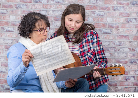 young teenager learning to play the guitar with 55413571