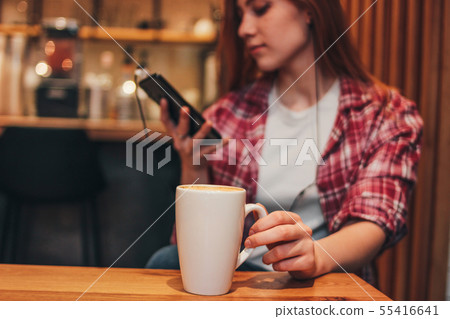 Cup of coffee cappuccino in female hands at cafe Cup of coffee cappuccino in female hands at cafe 55416641