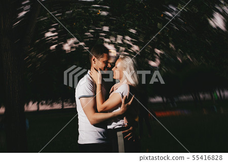 Young happy couple in love kissing in night park Young happy couple in love kissing in night park 55416828
