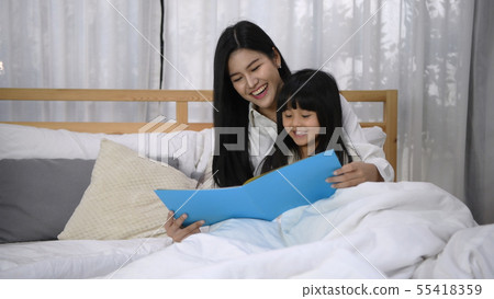 Family concept. The mother is telling the story to Family concept. The mother is telling the story to 55418359