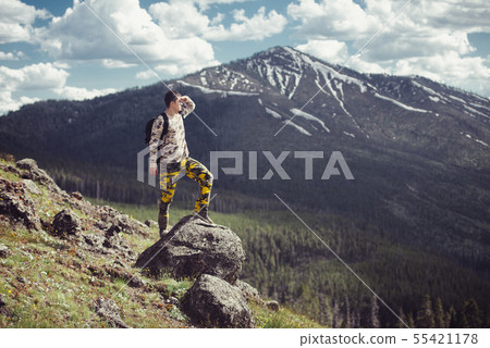Excited man hiking on a mountain top with backpack Excited man hiking on a mountain top with backpack 55421178