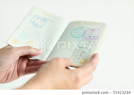 hands is holding passport with immigration stamp. 55423284
