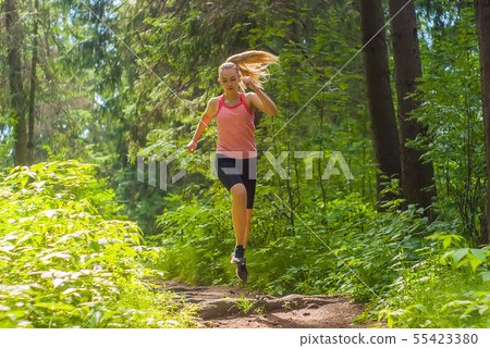 young woman jogging in a mountain forest 55423380