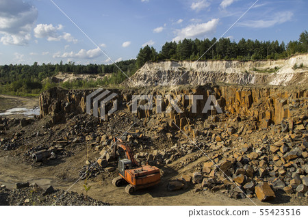 Excavator and basalt columns rocks. Heavy industry Excavator and basalt columns rocks. Heavy industry 55423516
