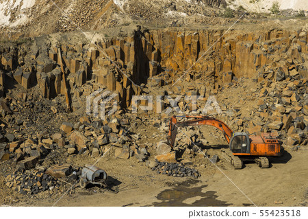 Excavator and basalt columns rocks. Heavy industry 55423518