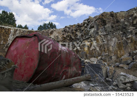 Basalt pillars. Red metal barrel. Stone excavation Basalt pillars. Red metal barrel. Stone excavation 55423523