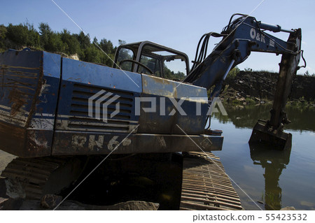 Excavator and basalt columns rocks. Heavy industry 55423532