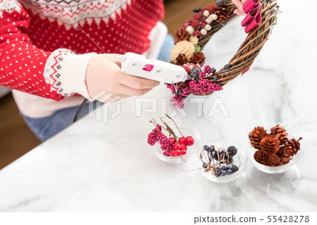 Woman making a Christmas wreath Woman making a Christmas wreath 55428278