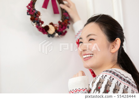 Woman making a Christmas wreath 55428444
