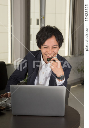 Work while eating rice balls while watching the computer screen 55428825