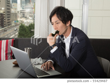 Men working while eating rice balls Men working while eating rice balls 55429487