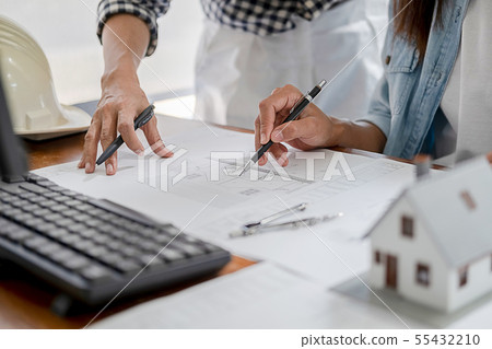 Engineers discuss a blueprint while checking 55432210